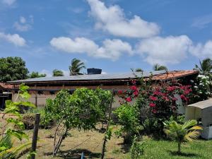 a house with flowers and plants in front of it at Casas Aluguel Temporada Pousada Village Maçarico in Salinópolis