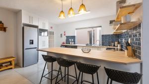 a kitchen with a counter with stools in it at Namib Nook in Swakopmund