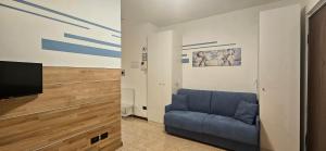 a living room with a blue couch and a flat screen tv at Dream House in Garbagnate Milanese