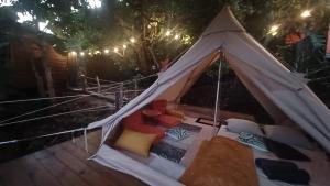 ein weißes Zelt mit einem Haufen Kissen darin in der Unterkunft Tipi camping in Capesterre-Belle-Eau