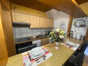 a kitchen with a table with a vase of flowers on it at Fewo 2 EG Sylt Westerland in Süderende