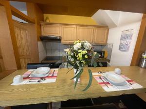 a kitchen table with a vase of flowers on it at Fewo 2 EG Sylt Westerland in Süderende