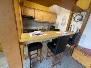 a small kitchen with a wooden table and chairs at Fewo 2 EG Sylt Westerland in Süderende +9 photos