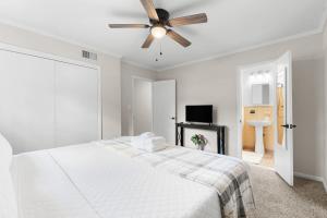 a white bedroom with a bed and a ceiling fan at Southern haven on granade - family retreat in Statesboro +14 photos