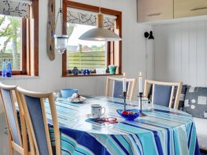 een eettafel met een blauw en wit tafelkleed bij Holiday Home Leocadia - 150m to the fjord by Interhome in Øsløs +20 foto's