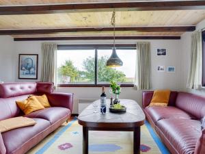 een woonkamer met 2 paarse banken en een tafel bij Holiday Home Leocadia - 150m to the fjord by Interhome in Øsløs