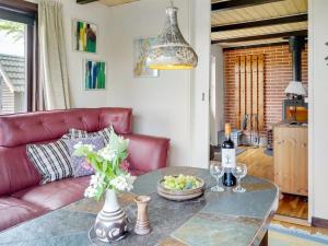 een woonkamer met een rode bank en een tafel bij Holiday Home Leocadia - 150m to the fjord by Interhome in Øsløs