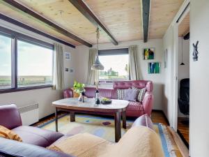 een woonkamer met rode meubels en een tafel bij Holiday Home Leocadia - 150m to the fjord by Interhome in Øsløs