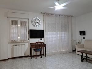a living room with a couch and a table and a television at Appartamento - terrazzo vivibile vista mare, wi-fi e box gratuiti in Vallecrosia