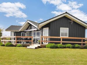 een zwart huis met een veranda en een hek bij Holiday Home Eberta - 200m to the fjord by Interhome in Vinderup