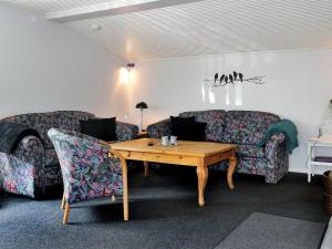 a living room with two couches and a wooden table at Holiday Home Assarina - 300m to the inlet by Interhome in Vinderup