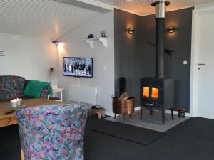 a living room with a couch and a wood stove at Holiday Home Assarina - 300m to the inlet by Interhome in Vinderup