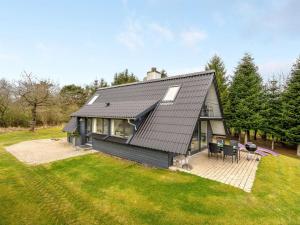 a black house with a patio and a yard at Holiday Home Brunhild - 300m to the inlet by Interhome in Fur