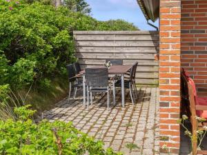 a table and chairs sitting on a brick patio at Holiday Home Bjarnger - 200m from the sea by Interhome in Frøstrup