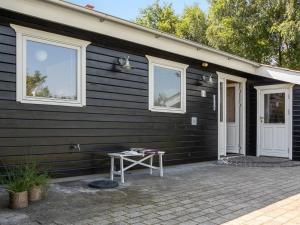a black house with a table in front of it at Holiday Home Kai - 500m to the fjord by Interhome in Struer
