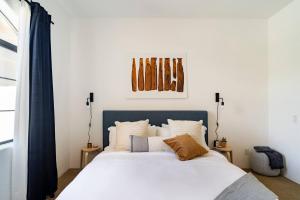 Un dormitorio con una cama grande con cabecero azul. en Designer Desert Condo! Poolhot Tub Dogs Welcome!, en La Quinta 20 fotos más
