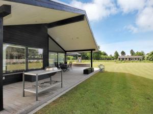 una casa con un ponte con un grill sopra di Holiday Home Etly - 600m to the fjord by Interhome a Roslev