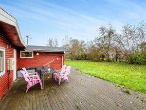 a deck with two pink chairs and a table at Holiday Home Scarlet - 400m to the inlet by Interhome in Vinderup +27 photos