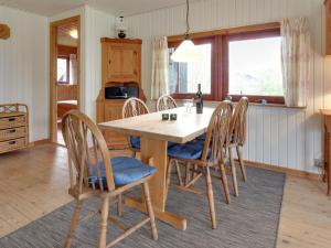 a dining room with a wooden table and chairs at Holiday Home Brimi - 450m from the sea by Interhome in Odder +12 photos