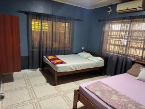 Un dormitorio con dos camas y paredes azules. en RA-SHA Apartments, en Paramaribo