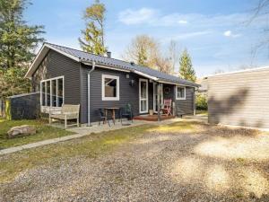 a small black house with a patio and a building at Holiday Home Milan - 250m to the fjord by Interhome in Thyholm