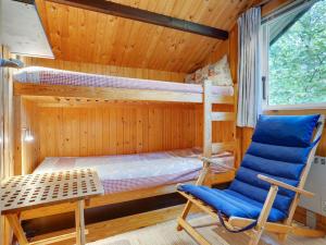 克内贝尔Holiday Home Herlek - 200m from the sea by Interhome的一间卧室配有两张双层床和一张蓝色椅子 更多10张照片