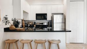kuchnia z białymi szafkami i blatem ze stołkami w obiekcie Designer Condo 2 Beds Sleeps 4 Dogs Welcome! w mieście La Quinta +11 zdjęć