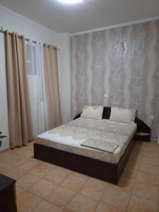 een slaapkamer met een bed in een kamer met gordijnen bij Lia Apartment Sea View in Nea Fokea