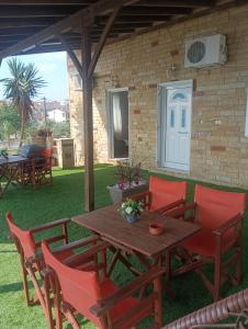 een houten tafel en stoelen op een terras bij Lia Apartment Sea View in Nea Fokea