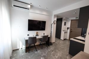a living room with a table and chairs and a television at LP Citycenter Suite 2 in Serres