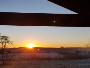 a sunset in a field with a dirt road at Holiday Home Siebelt - 200m from the sea by Interhome in Knebel