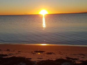 a sunset on the beach with the sun reflecting in the water at Holiday Home Siebelt - 200m from the sea by Interhome in Knebel
