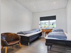 2 Betten in einem Zimmer mit einem Stuhl und einem Schreibtisch in der Unterkunft Holiday Home Anniina - 200m from the sea by Interhome in Knebel