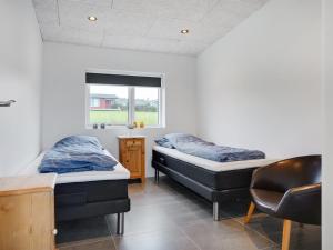 2 Betten in einem Zimmer mit einem Stuhl und einem Fenster in der Unterkunft Holiday Home Anniina - 200m from the sea by Interhome in Knebel + 13 Fotos