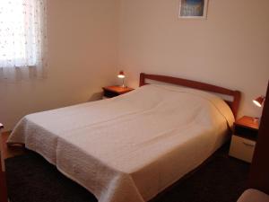 1 dormitorio con 1 cama blanca y 2 mesitas de noche en Apartments Dadic Cavtat, en Cavtat