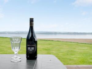 a bottle of wine and a glass sitting on a table at Holiday Home Henrieke - 250m to the inlet by Interhome in Roslev