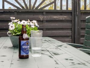 a bottle of beer sitting on a table with a glass at Holiday Home Henrieke - 250m to the inlet by Interhome in Roslev