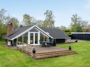 a house with a wooden deck in a yard at Holiday Home Henrieke - 250m to the inlet by Interhome in Roslev