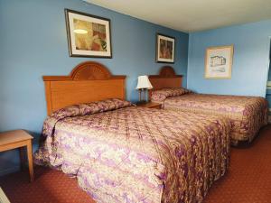 two beds in a hotel room with blue walls at Valley Motel By Townhouse Corpus Christi Near Airport I 37 in Corpus Christi
