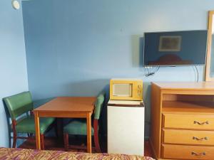 a room with a desk and a table and a tv at Valley Motel By Townhouse Corpus Christi Near Airport I 37 in Corpus Christi