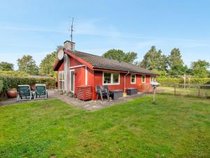 una casa roja con sillas en un patio en Holiday Home Anselm by Interhome, en Fårvang 15 fotos más