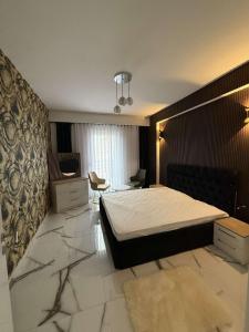 a bedroom with a bed and a desk in it at B&B Apartment Prishtina in Pristina