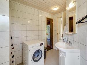 a bathroom with a washing machine and a sink at Holiday Home Ernestina - 500m from the sea by Interhome in Glesborg +17 photos