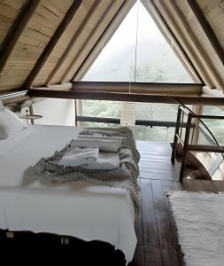 una cama en una habitación con una ventana grande en Di Vino Chalé Blanc - Serra da Moeda, en Vieira de Cima 16 fotos más