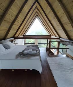 una cama en una habitación con una ventana grande en Di Vino Chalé Blanc - Serra da Moeda, en Vieira de Cima