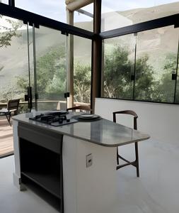 cocina con fogones y mesa con vistas en Di Vino Chalé Blanc - Serra da Moeda, en Vieira de Cima