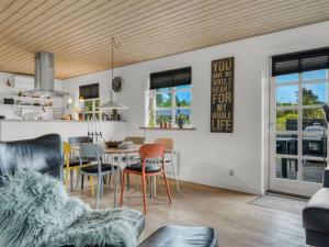 a dining room and living room with a table and chairs at Holiday Home Christina - 300m to the inlet by Interhome in Storvorde
