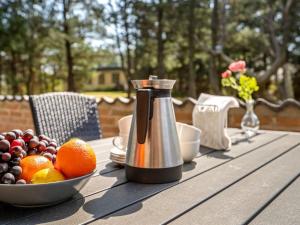 a table with a coffee pot and a bowl of fruit at Holiday Home Ehlin - 150m from the sea by Interhome in Sæby