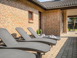 a row of chairs sitting in front of a brick building at Holiday Home Ehlin - 150m from the sea by Interhome in Sæby