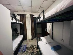 a small room with two bunk beds in it at Premiere Inn Hostel Hiriketiya in Dickwella